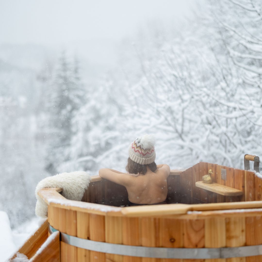 a person soaking in a hot tub in the snow