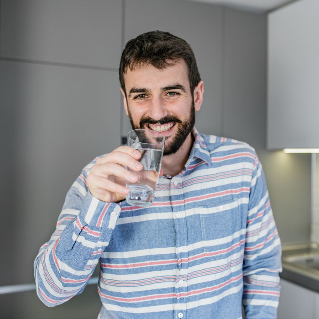 a man drinking water happily
