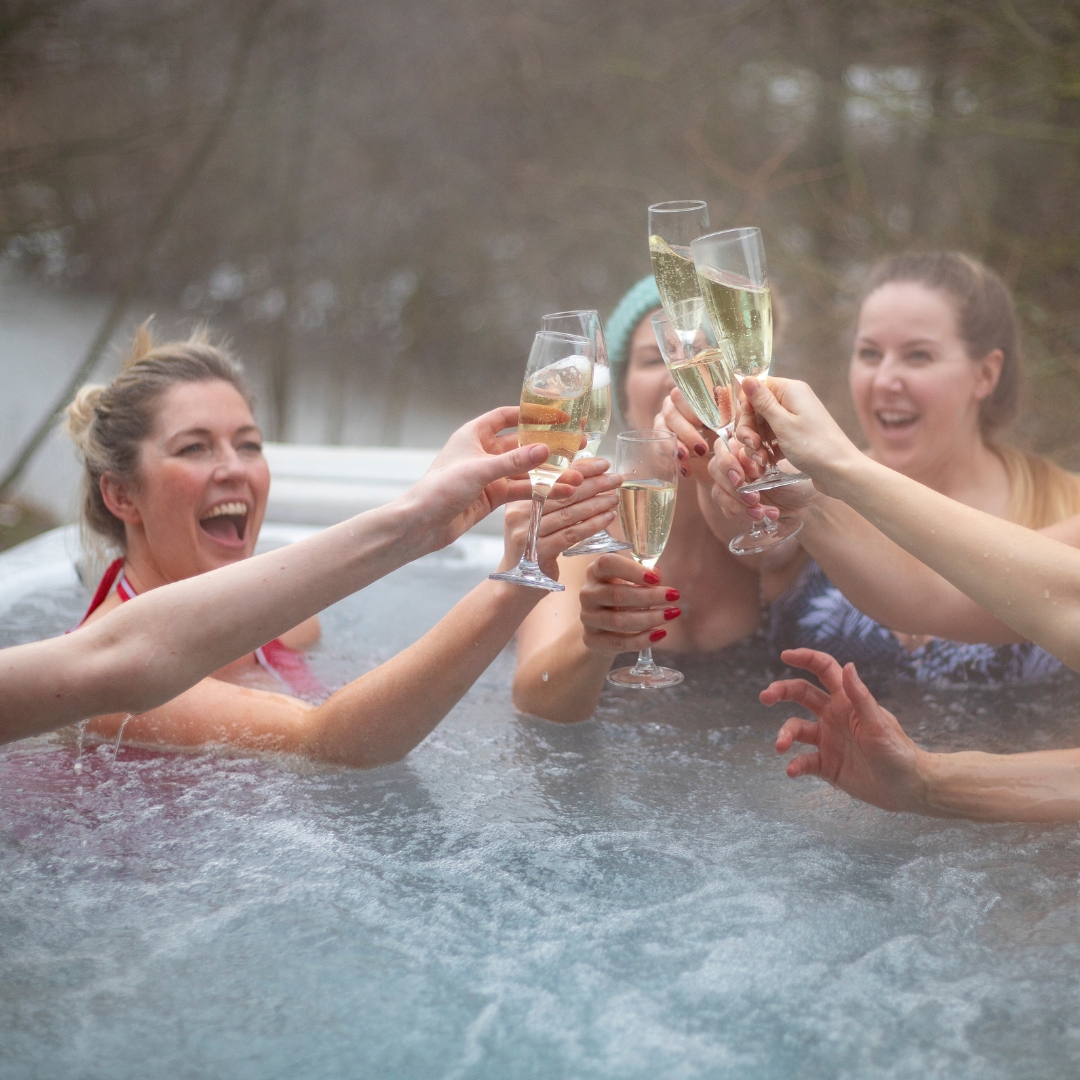 Friends having champagne in a hot tub